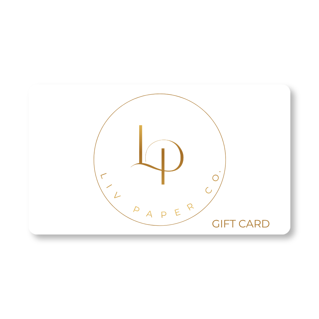 A white rectangular Liv Paper Co. gift card with a gold circular logo and the words 'LIV PAPER CO.